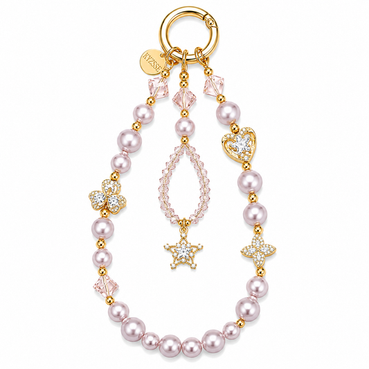 A gold-plated charm keychain featuring light pink faux pearls, pink faceted crystals, a heart-shaped crystal charm, a clover charm, and a teardrop crystal charm with a star accent, all attached to a gold split ring.